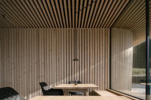 a table and chairs in a room with a wooden wall at anders mountain suites 3 in Brixen
