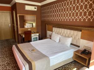 a bedroom with a large bed and a mirror at Demosan City Hotel in Konya