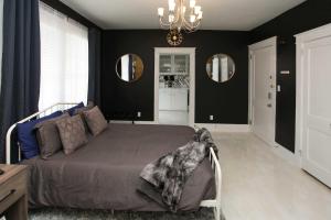 a bedroom with a bed and a chandelier and mirrors at Stunning Alabama Studio about 2 Mi to Dtwn Mobile! in Mobile