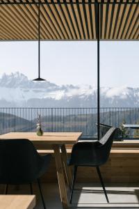 a table and chairs in front of a large window at anders mountain suites 6 in Brixen