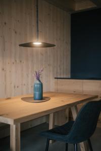 a table with a blue vase with flowers in it at anders mountain suites 6 in Brixen