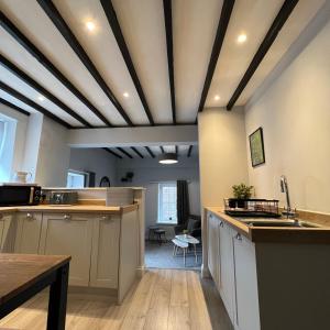a kitchen with a coffered ceiling and wooden floors at Honeysuckle Cottage & Whinfell Studio in Penrith