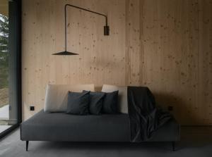 a bed in a room with a wooden wall at anders mountain suites 6 in Brixen