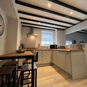 una grande cucina con tavolo e bancone di Honeysuckle Cottage & Whinfell Studio a Penrith