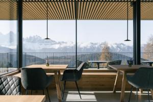 a restaurant with tables and chairs and a large window at anders mountain suites 6 in Brixen