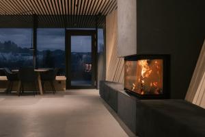 a fireplace in a room with a table and chairs at anders mountain suites 6 in Brixen
