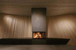 a fireplace in a room with wooden walls at anders mountain suites 6 in Brixen