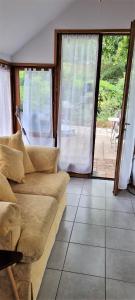 a living room with a couch and a large window at River Cottage in Balledent