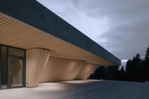 a building with a wooden facade with a glass door at anders mountain suites 6 in Brixen