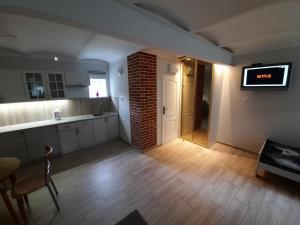 cocina con TV y pared de ladrillo en apartament typu agro z tarasem, en Milicz