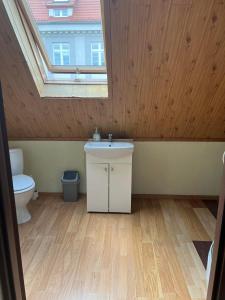 a bathroom with a sink and a toilet with a skylight at Hostel BAZA 15 in Wrocław