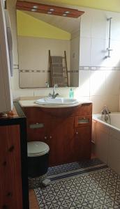 a bathroom with a sink and a toilet and a tub at La Caz'Anna in Cilaos