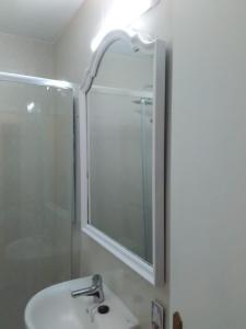 a bathroom with a sink and a shower and a mirror at APARTAMENTO RAFER in Ribadeo