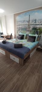 a bedroom with a large bed with a mural of the eiffel tower at Velvita Central in Sliven