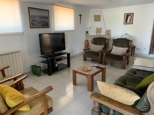 a living room with chairs and a flat screen tv at Hotel Mateus in Fátima