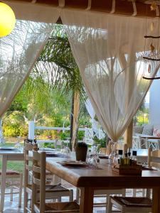 comedor con mesa y sillas con cortinas en Rida Village Ksamil Island, en Ksamil