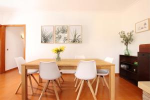 comedor con mesa de madera y sillas blancas en Villa Magraner Catalina, en Pollensa