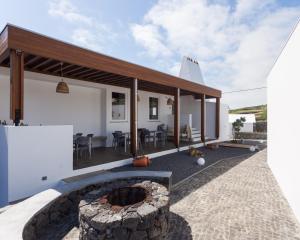 una casa con una hoguera en el patio trasero en Casa dos Romeiros, en Santa Bárbara