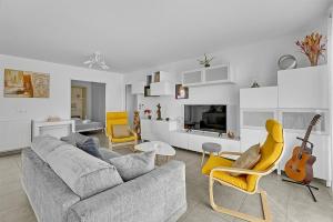 a living room with a gray couch and yellow chairs at Le Patio Guilhemery in Toulouse