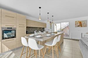 a kitchen with a table and white stools at Le Patio Guilhemery in Toulouse