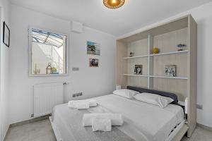 a white bedroom with a large bed with white pillows at Le Patio Guilhemery in Toulouse