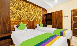 a hotel room with two beds and a painting on the wall at Treebo Trend Spring Brook in Guwahati