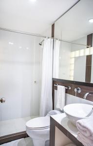 y baño con aseo blanco y lavamanos. en Santorini Villas Santa Marta, en Santa Marta