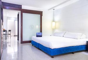 Un dormitorio con una cama con una maleta azul. en Santorini Villas Santa Marta, en Santa Marta