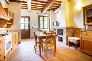 uma cozinha com uma mesa, cadeiras e um fogão em Borgo La Casa em Montaione