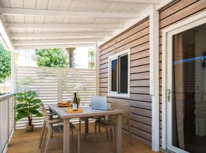 eine Terrasse mit einem Tisch und einem Laptop darauf in der Unterkunft Rimini Family Village in Rimini