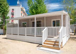 a small house with a white fence and stairs at Club del Sole Rimini Family Resort in Rimini