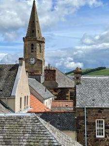 a church with a clock tower on top of roofs at Towerwell in Newburgh