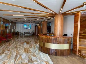 a lobby with a large stone floor and a bar at Murex Plaza Hotel & Suites in Monrovia