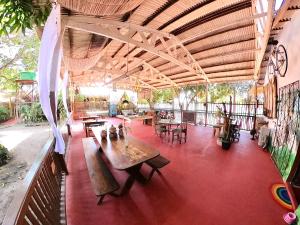 an outdoor patio with tables and chairs and a roof at Pousada Ocazum in Alter do Chao