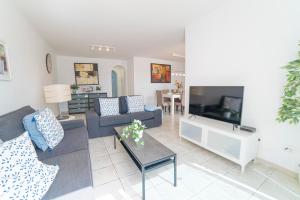 a living room with a couch and a tv at Coloradas Villa Alba in Playa Blanca