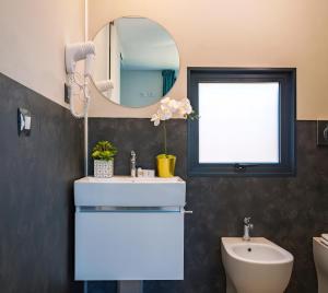 a bathroom with a sink and a mirror at Club del Sole Rimini Family Resort in Rimini