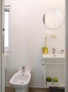 a bathroom with a sink and a toilet and a mirror at Club del Sole Rimini Family Resort in Rimini