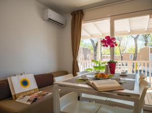 a living room with a table and a couch at Club del Sole Rimini Family Resort in Rimini