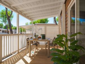 a patio with a table and chairs on a deck at Club del Sole Rimini Family Resort in Rimini
