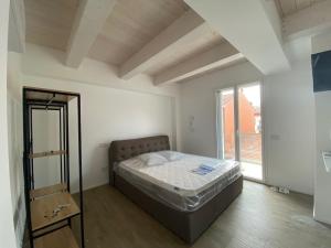 a bedroom with a bed and a large window at Appartamenti nuovi in centro a Porto Recanati Riviera del Conero in Porto Recanati