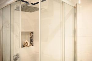 una ducha con puerta de cristal en un baño en Casa Bea, en Nápoles 41 fotos más