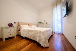 Un dormitorio con una cama, una cómoda y un televisor. en Casa Bea, en Nápoles