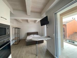 a room with a bed and a table with a television at Appartamenti nuovi in centro a Porto Recanati Riviera del Conero in Porto Recanati