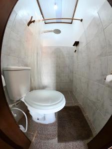 uma casa de banho com um WC branco e um espelho. em Pousada Ocazum em Alter do Chão