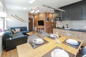 Il comprend une cuisine et un salon avec une table et des chaises. dans l'établissement VacationClub - Stone Hill Apartament 5, à Szklarska Poręba