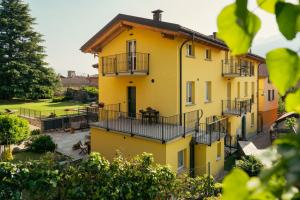 żółty dom z balkonem i dziedzińcem w obiekcie Residence Antico Torchio w mieście Dervio +37 zdjęć