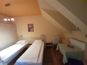 um quarto com três camas e uma mesa em Pensiunea Zodiac em Timisoara