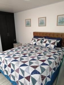 een slaapkamer met een bed met een quilt bij Hostal Raatid Manchy in San Andrés