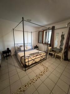 1 dormitorio con cama con dosel y silla en La Mimosa, en Porto Garibaldi