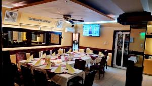 a dining room with tables and chairs and a tv at Pensiunea Zodiac in Timişoara